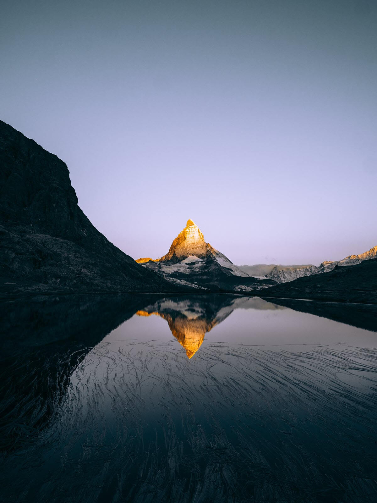 Sunrise illuminating the tip of Mt. Blanc in Switzerland near Zermatt, reflected in the Riffelsee